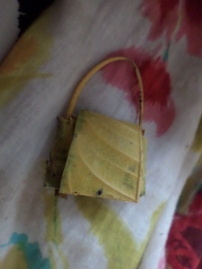 A purse is fashioned from a leaf for a child's toy