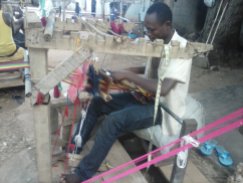 Fabric is being weaved on a manual loom